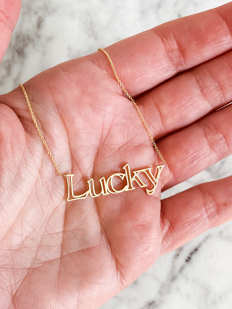 The lucky necklace held inside the palm of a hand.