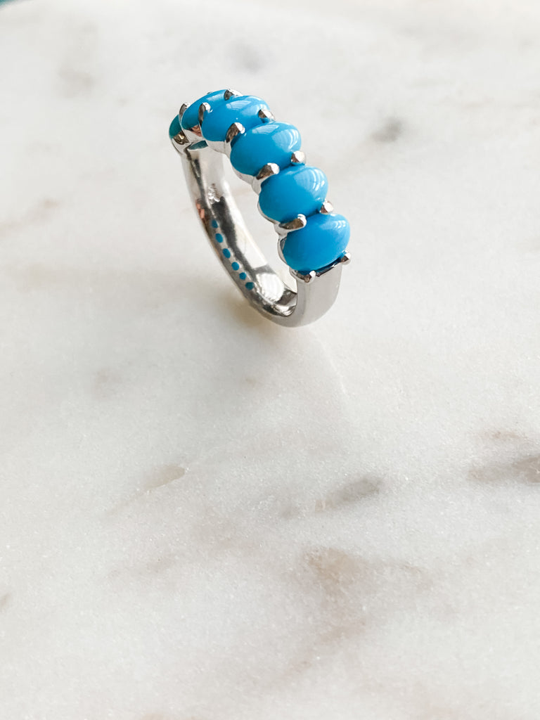 Six turquoise stones are set on the shank of the ring.