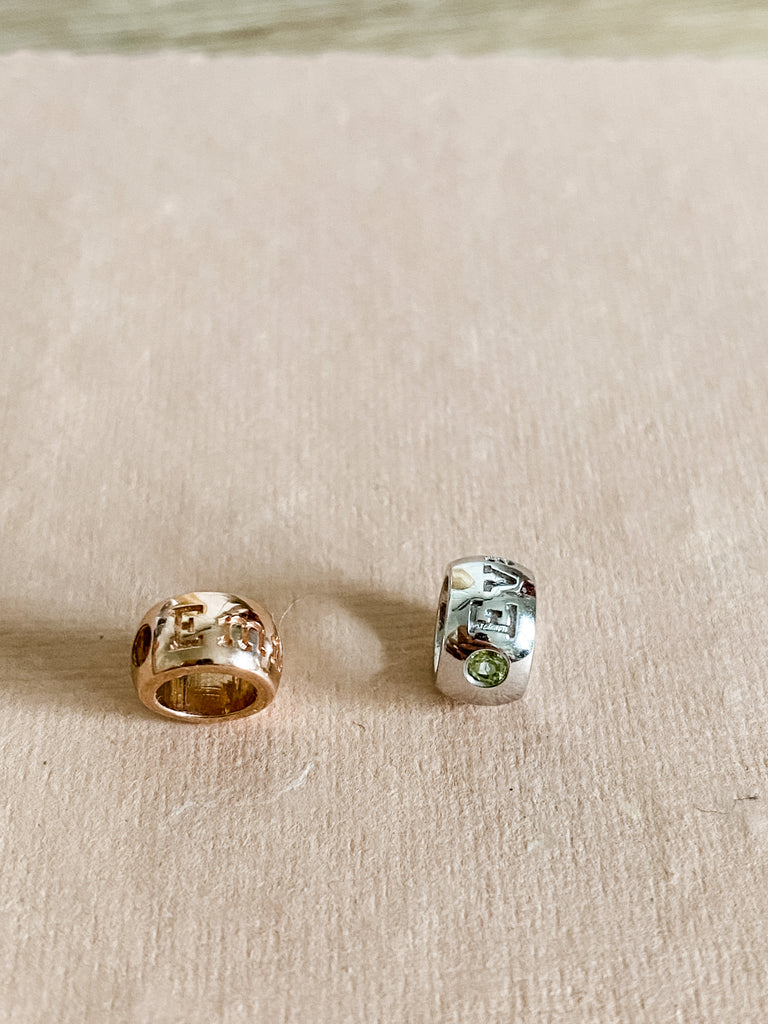 The beads on a surface. A birthstone and name can be found on each.